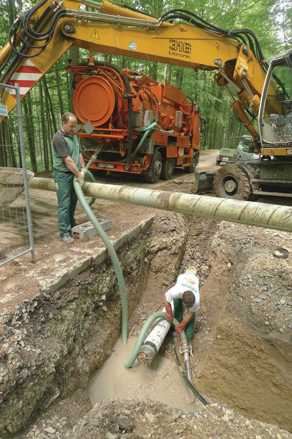 men laying pipe under rural road