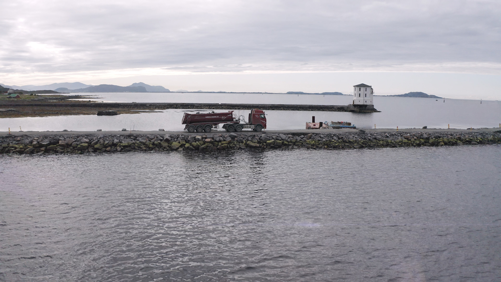 Excavated rock is being hauled from the tunnel excavations for the causeway construction operation 