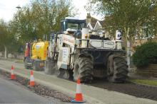 Spreading material to strengthen the tar bound road