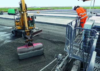 Concrete was placed in front of the SP 62i slipform paver by an excavator and then distributed with the spreader plow