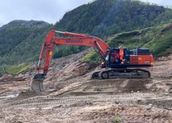 Transport Minister Jon-Ivar Nygård at the controls of an excavator, helped by a Skanska employee, on site of the E10 Tjeldsund-Gullesfjordbotn-Langvassbukt road project (image courtesy Erik Betten/State Road Administration)